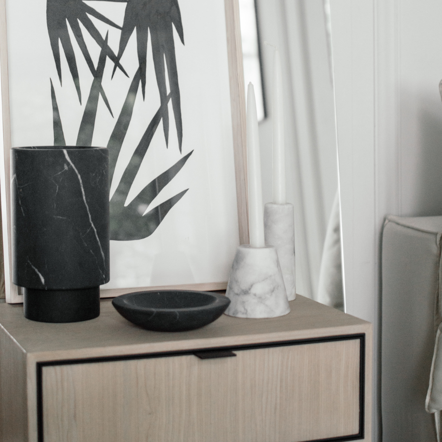 bedside table with small black marble bowl and vases on top