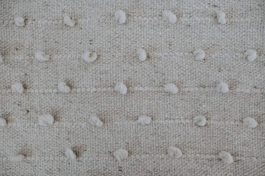 detail of wool fabric with pom poms